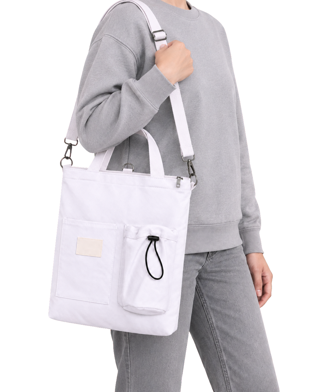 The same white tote worn over one shoulder on the long clip-on strap
